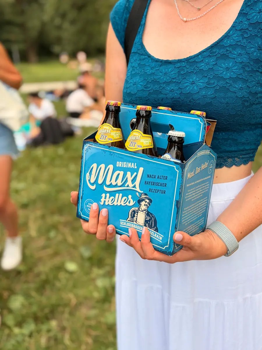 Ein Maxl.Helles-Sechserträger in den Händen